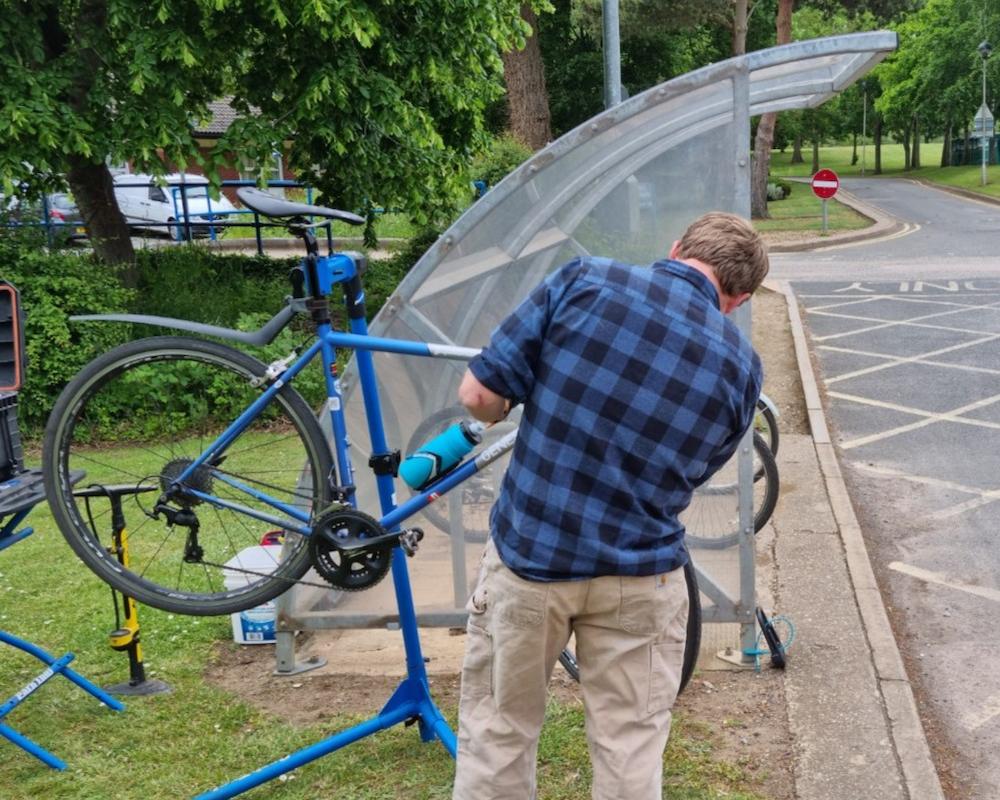 An image of Dr Bike fixing a bike at a workplace