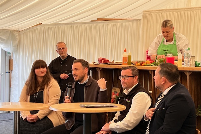 Four people sat discussing something using a microphone