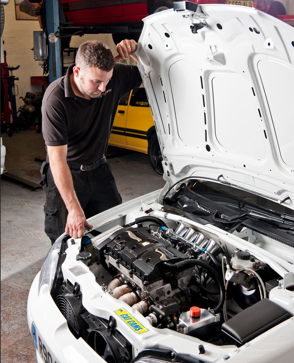 Mechanic checking vehicle engine.