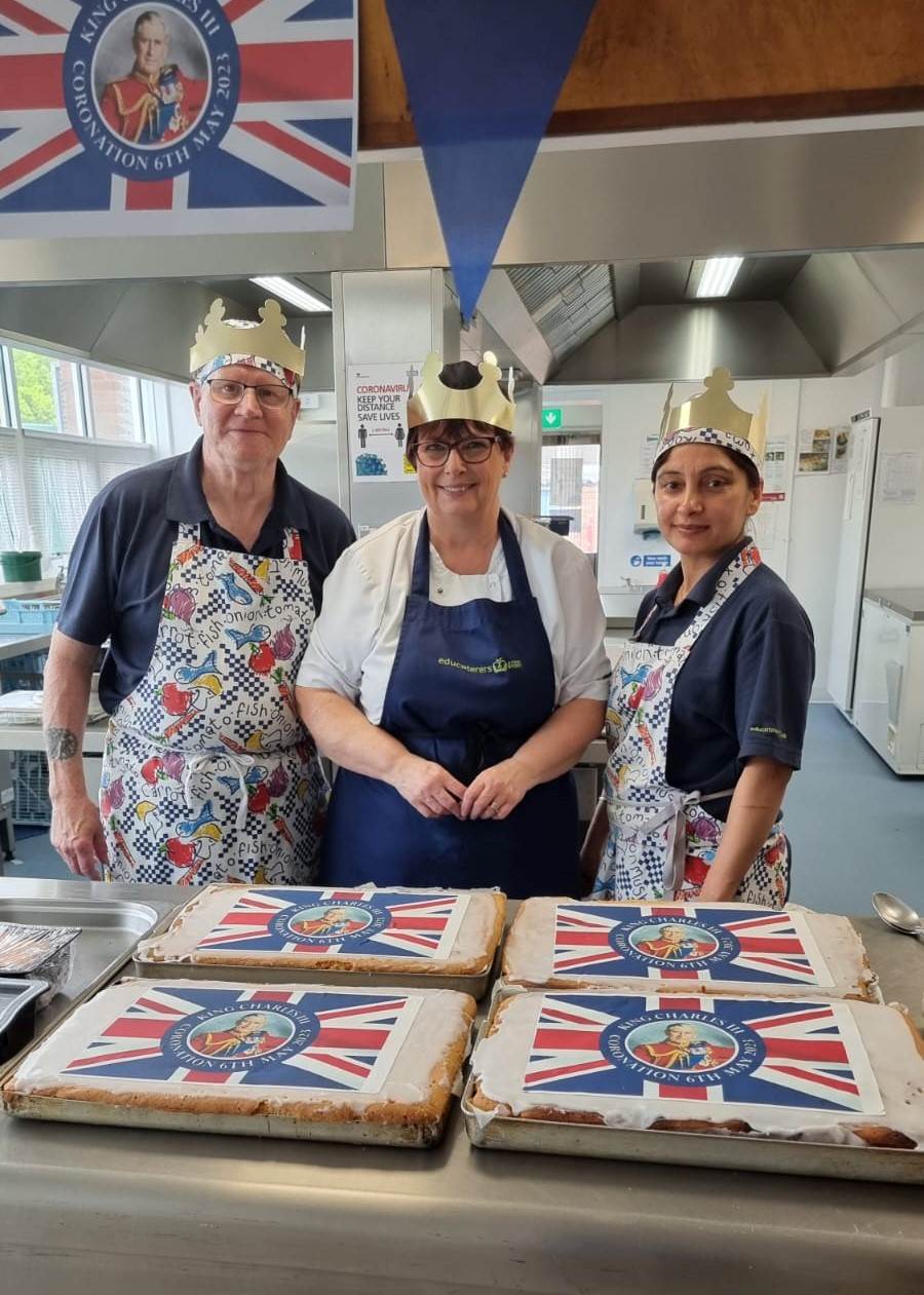 Left to right: Tom Haynes, Catering Assistant;  Carol Haynes, Head of Kitchen;  and Tina Bansal, Catering Assistant get ready to serve up a Coronation menu at Telford Junior School, Leamington.