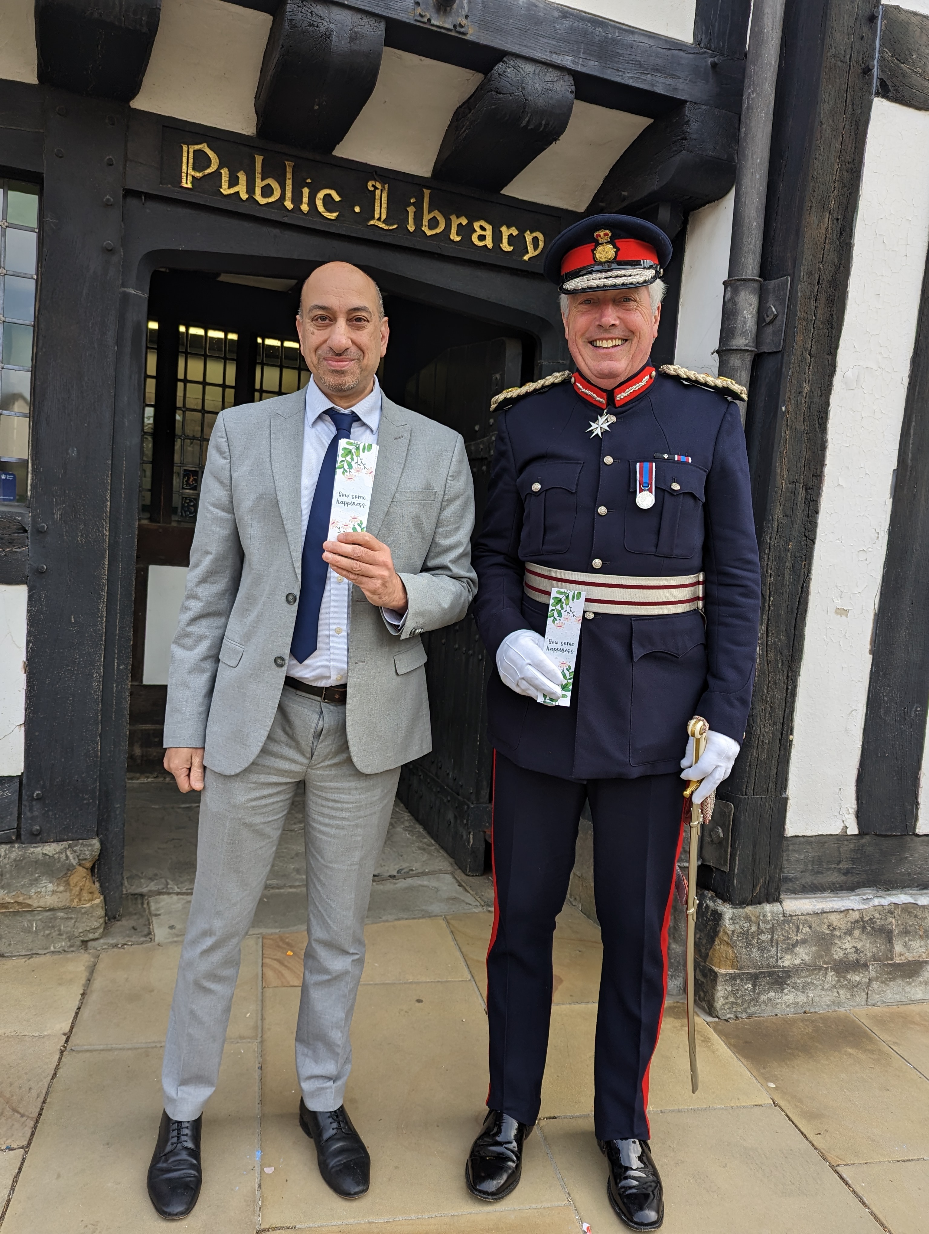 Business & Customer Services Manager Ayub Khan with Lord Lieutenant Tim Cox and Warwickshire Libraries Coronation seed bookmarks.