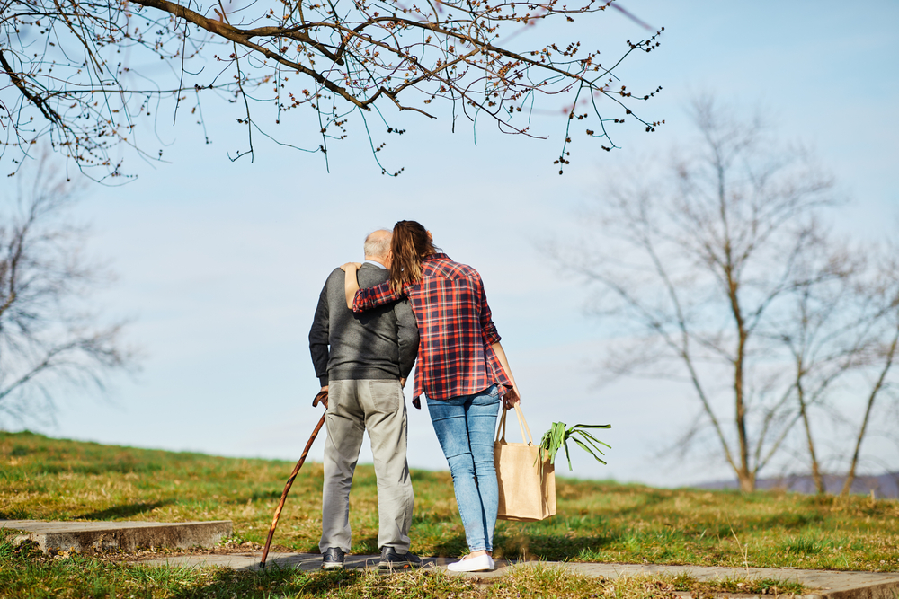 Old man with young lady next to him, looking out at the sky