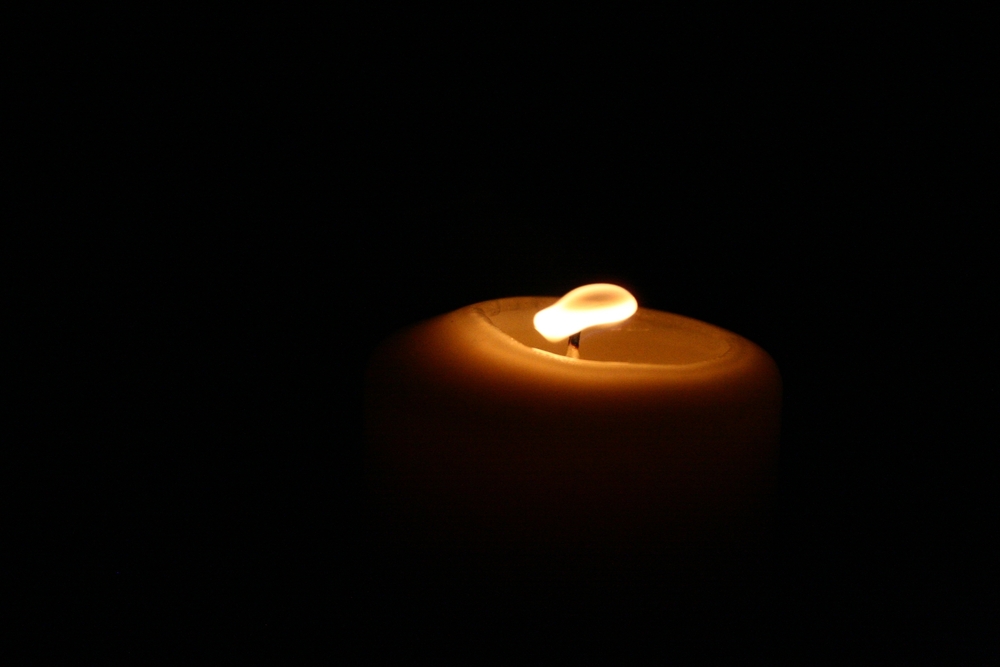 A lit candle with black background