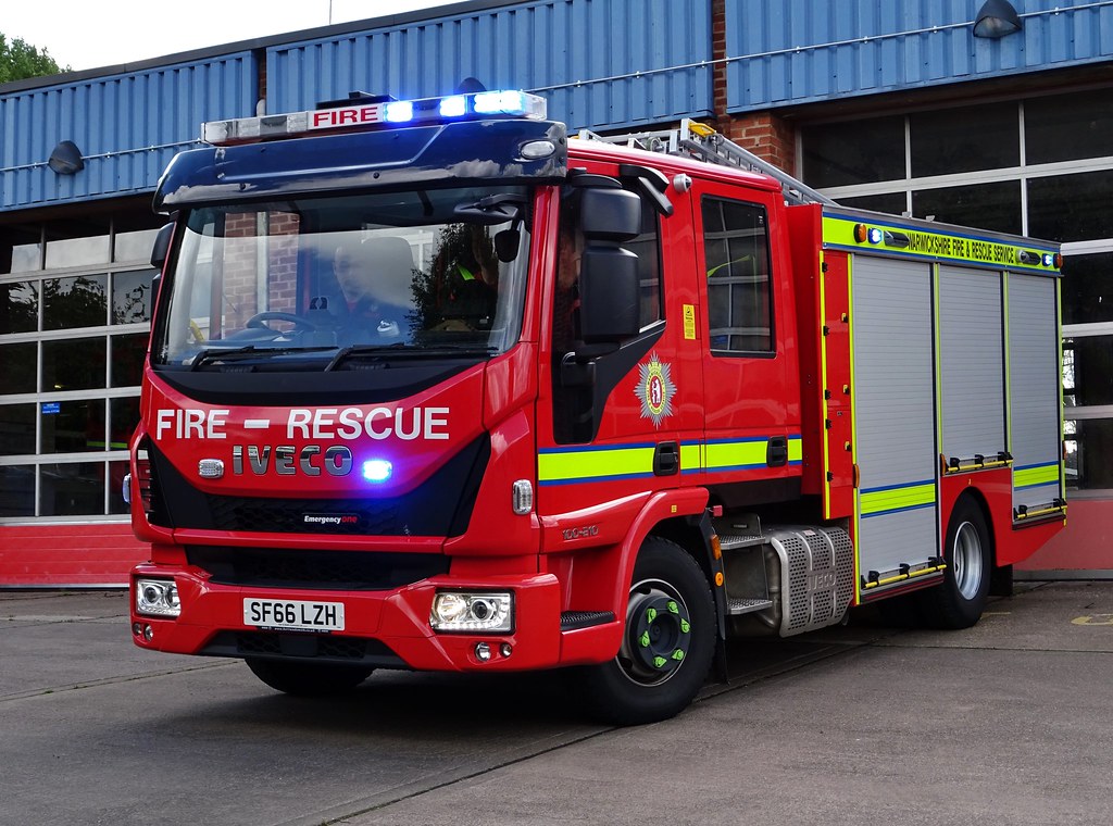 Warwickshire Fire and Rescue Service fire engine pulling out of station with lights flashing